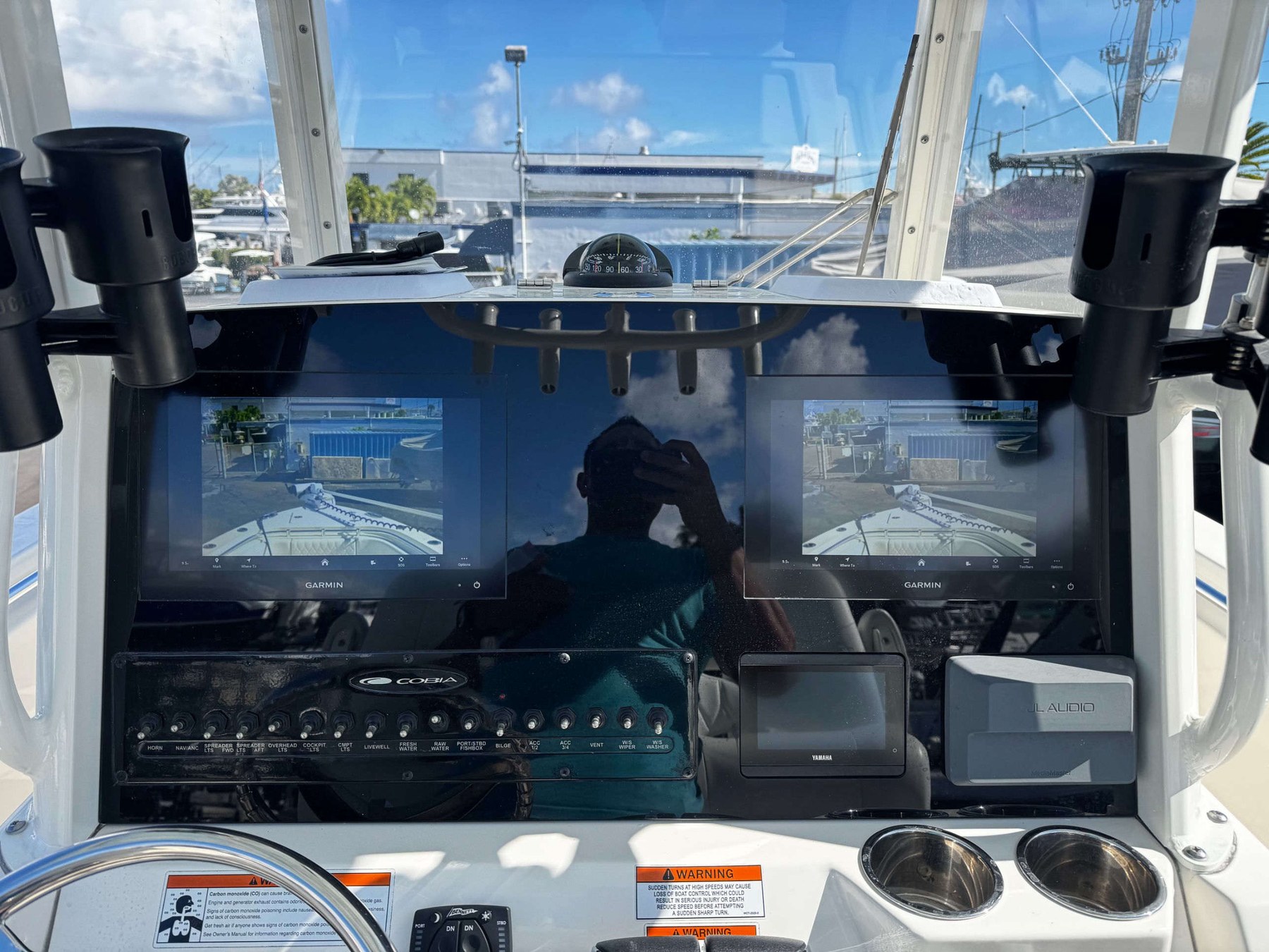 Cobia center console — dual Garmin displays with backup cameras over a full JL Audio and switch bank