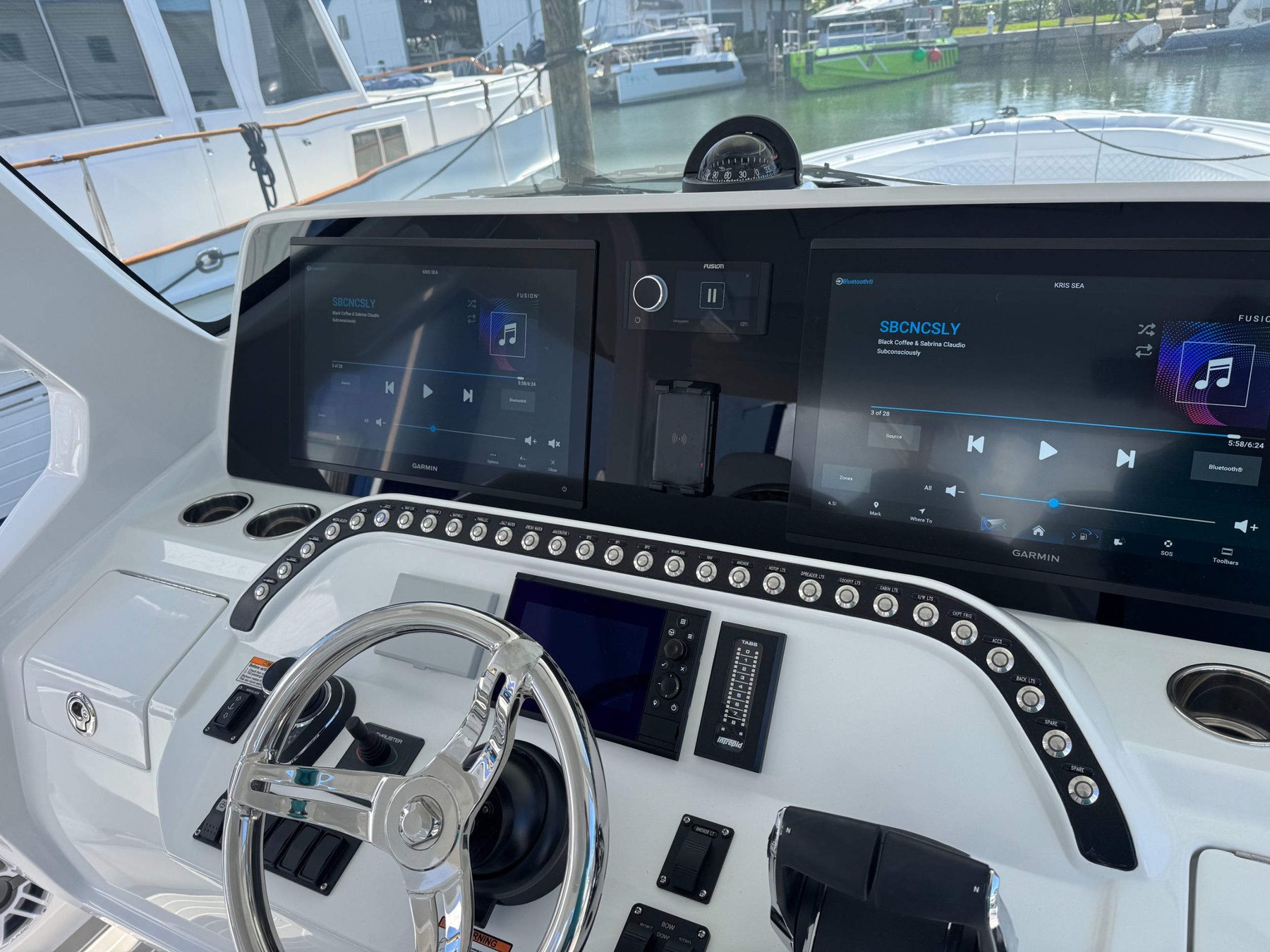 Intrepid helm — dual Garmin displays with Fusion audio and custom black billet switch panels